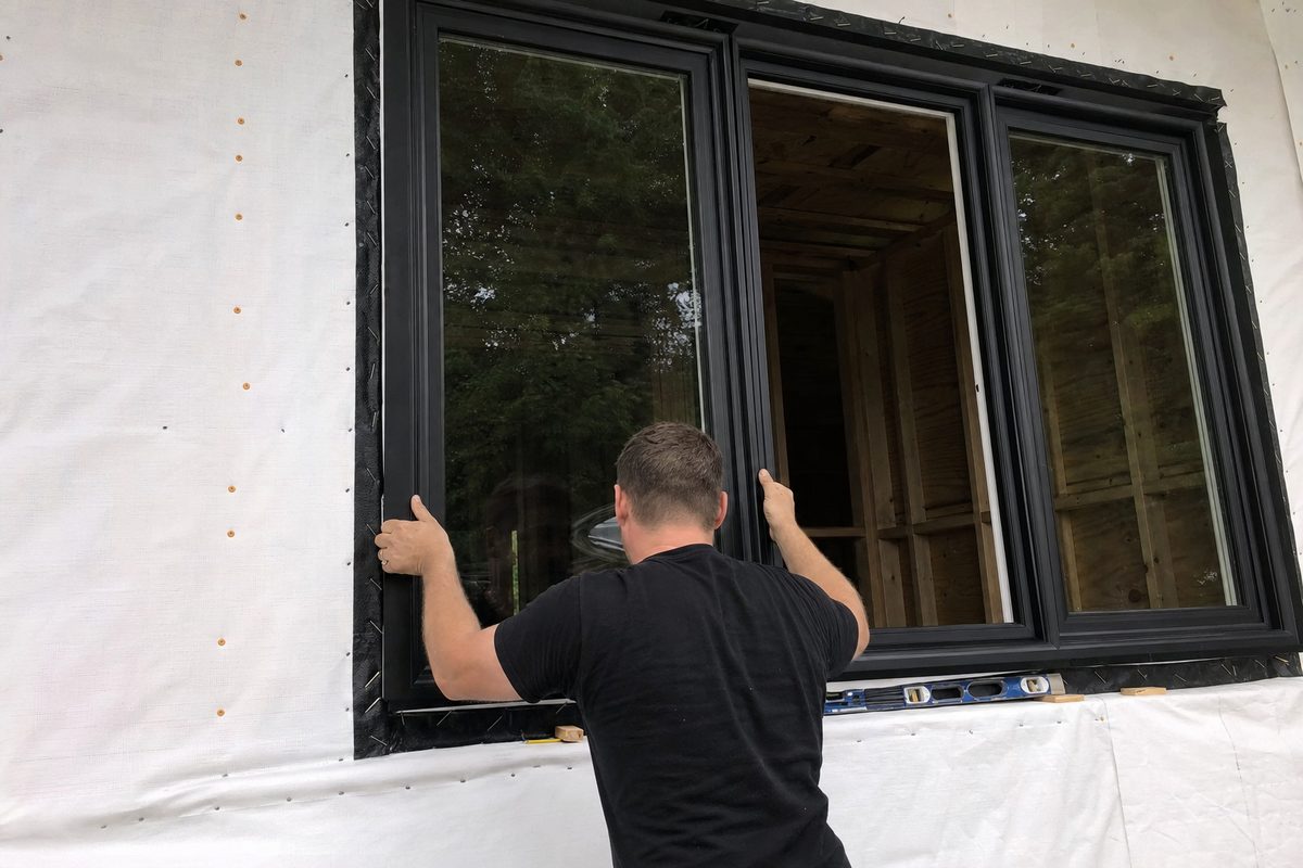 Setting a new black-framed replacement window into a flashed rough opening