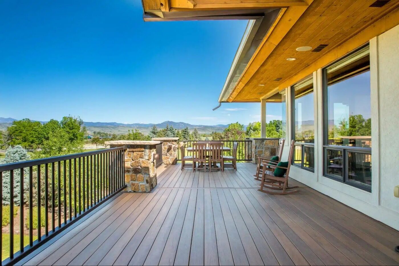 Elevated wood deck with black aluminum railing among pines near Spokane