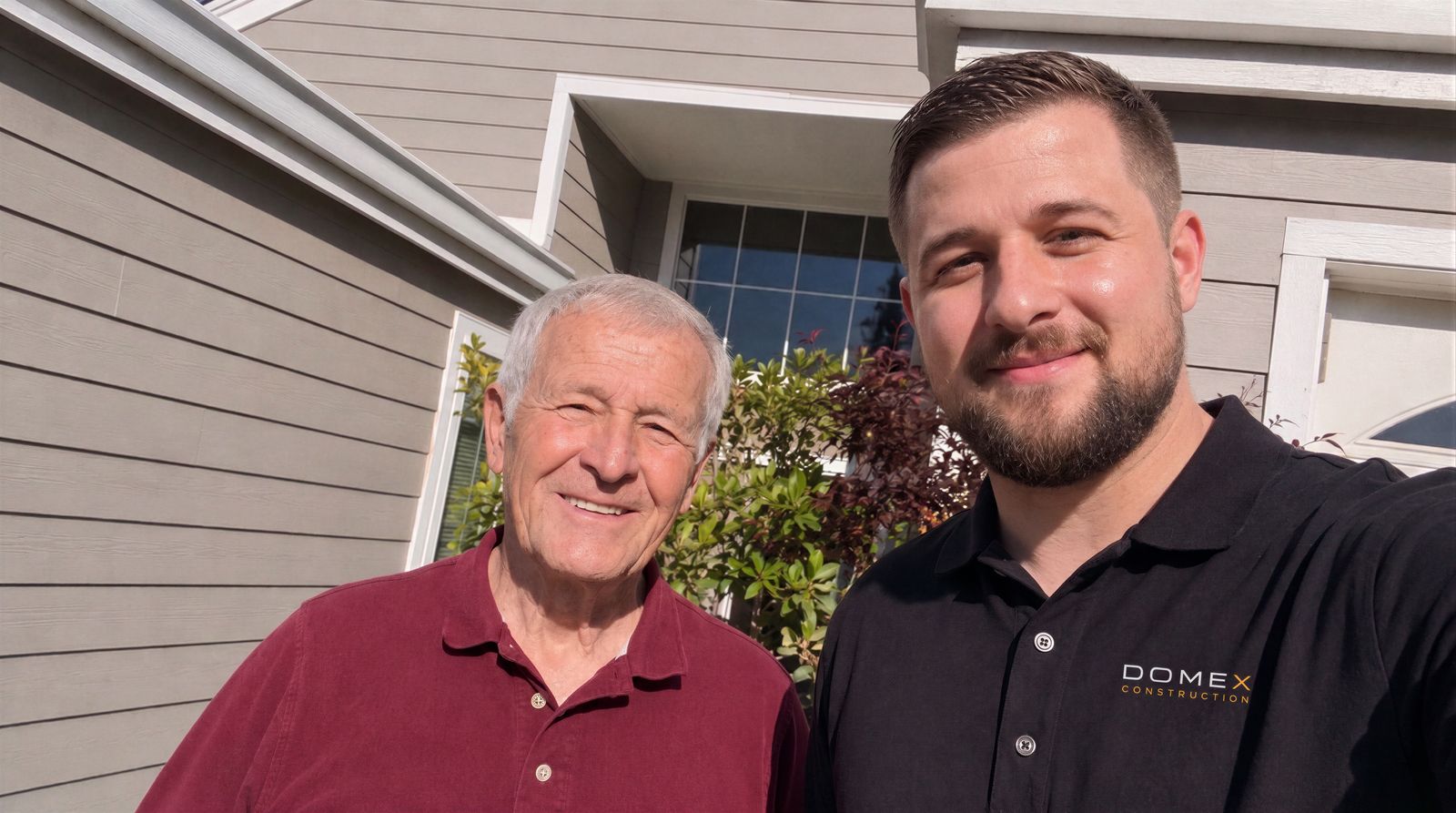Domex Construction lead with a happy homeowner in front of their re-sided home