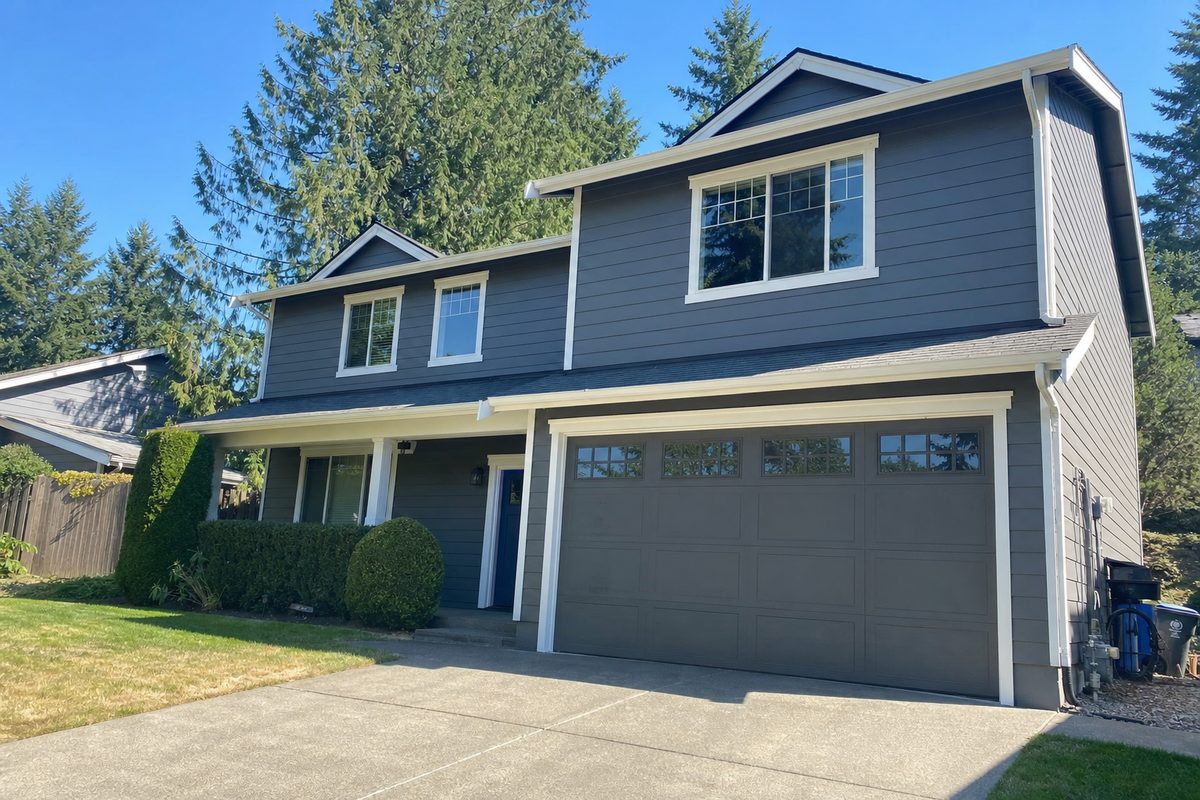 Two-story home freshly re-sided in charcoal fiber-cement lap siding at dusk