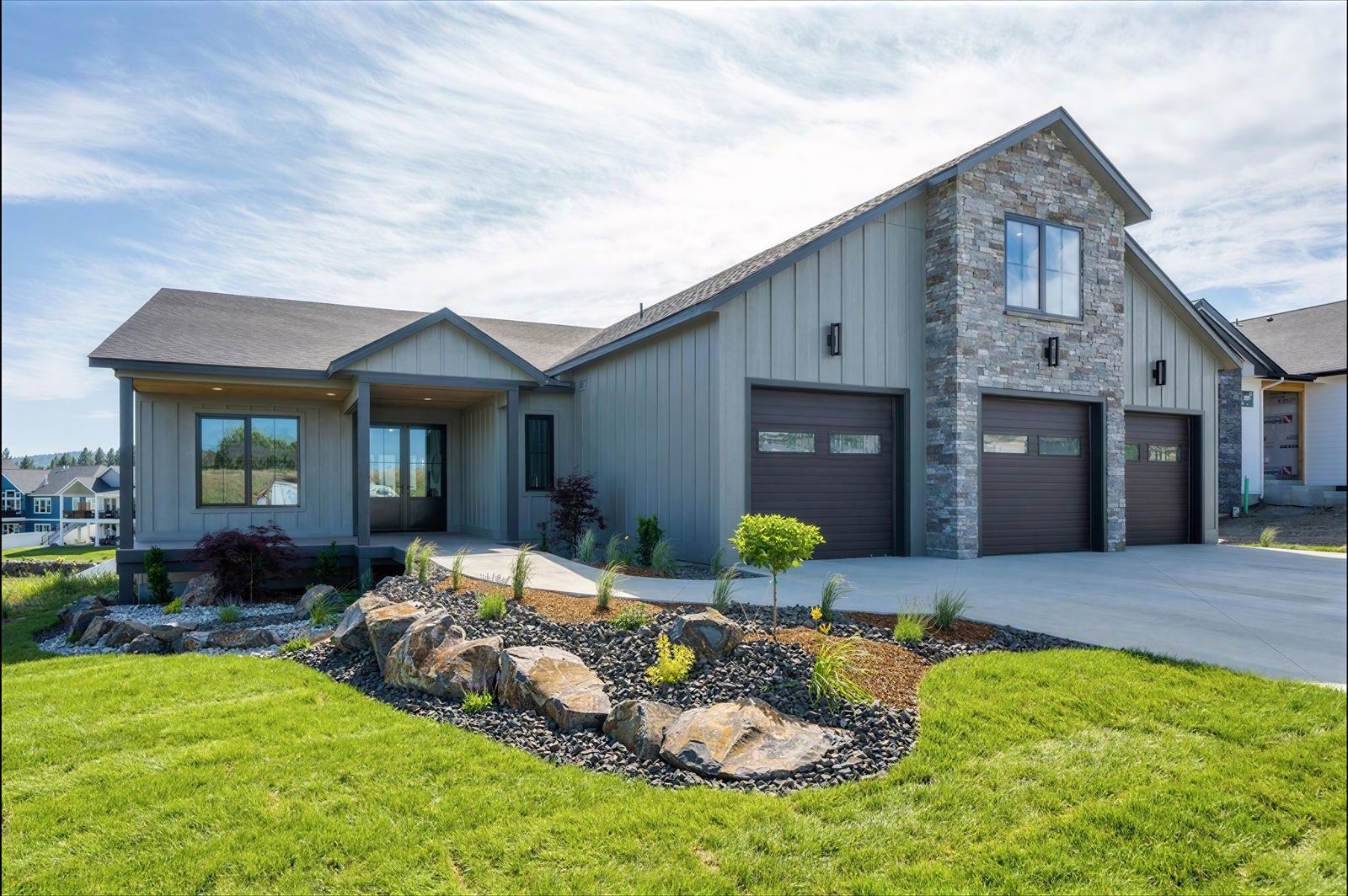 Greige board-and-batten ranch home with stone accents near Coeur d'Alene