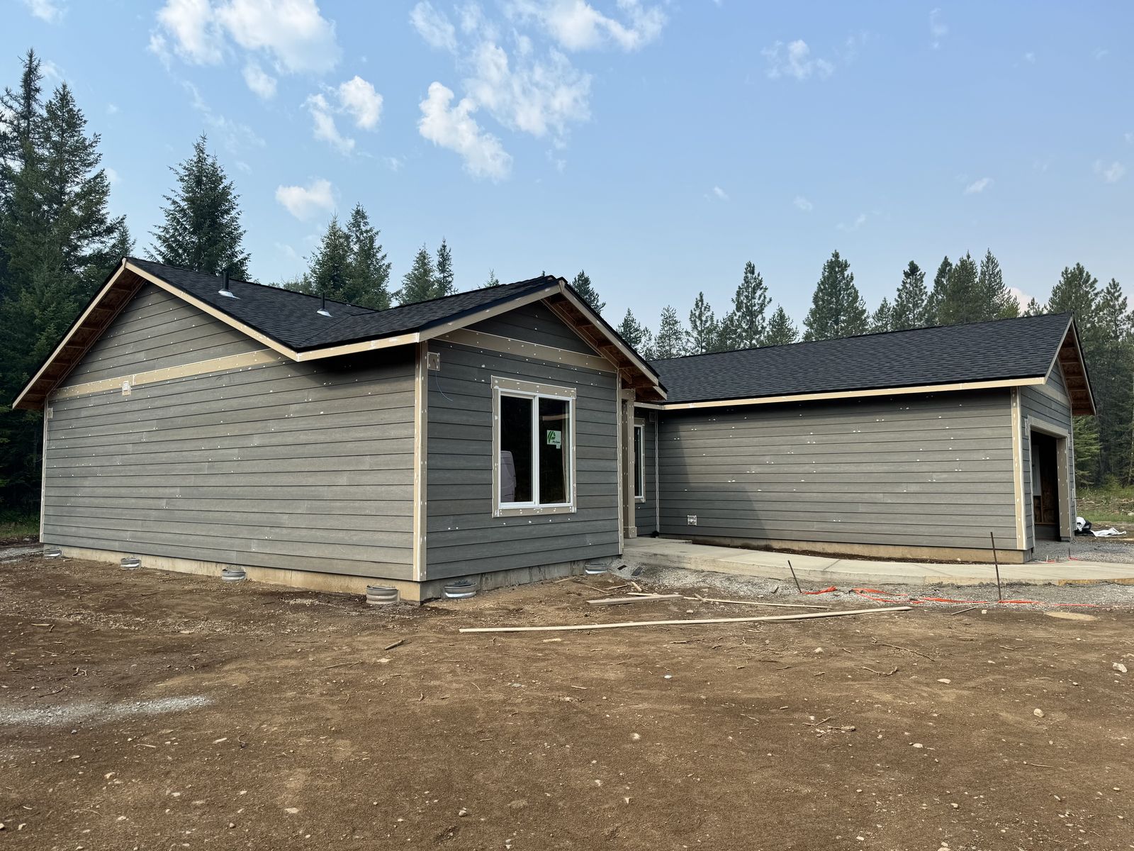 New single-level home in the pines at Nine Mile Falls with fresh gray lap siding